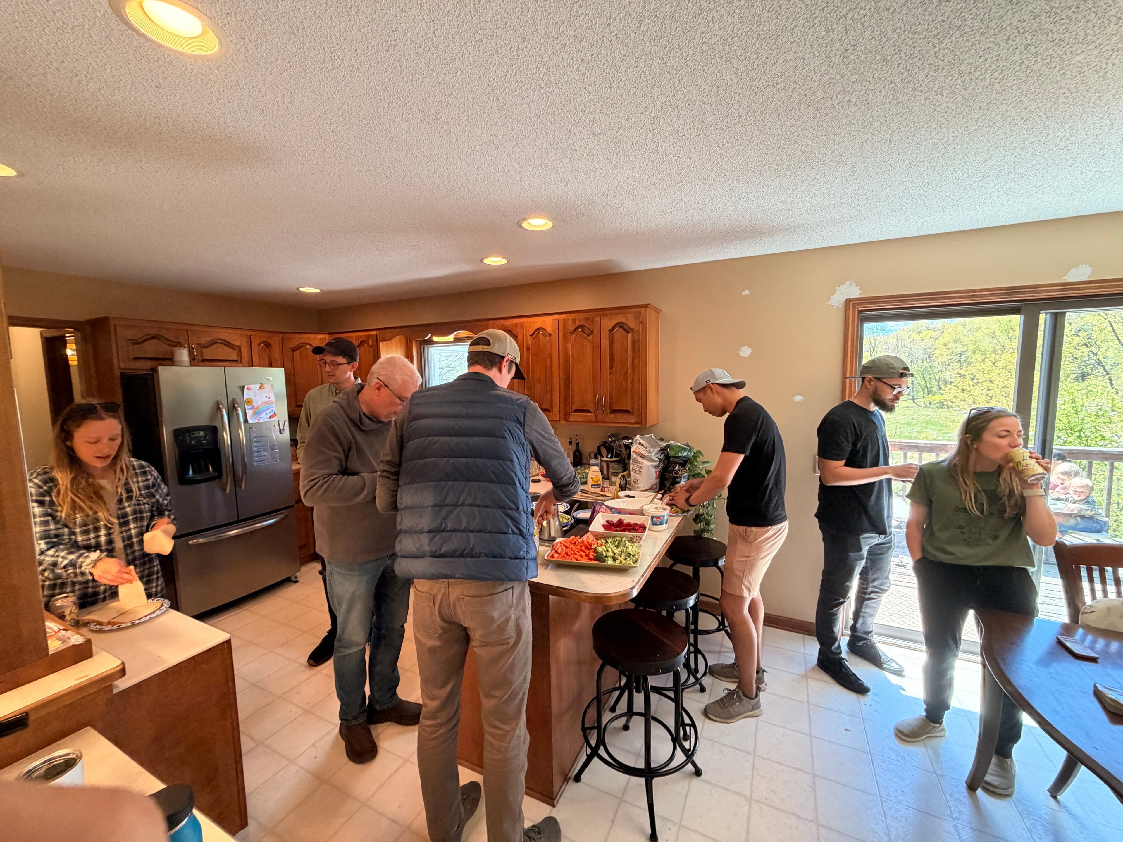 Several people preparing a shared meal in a home kitchen