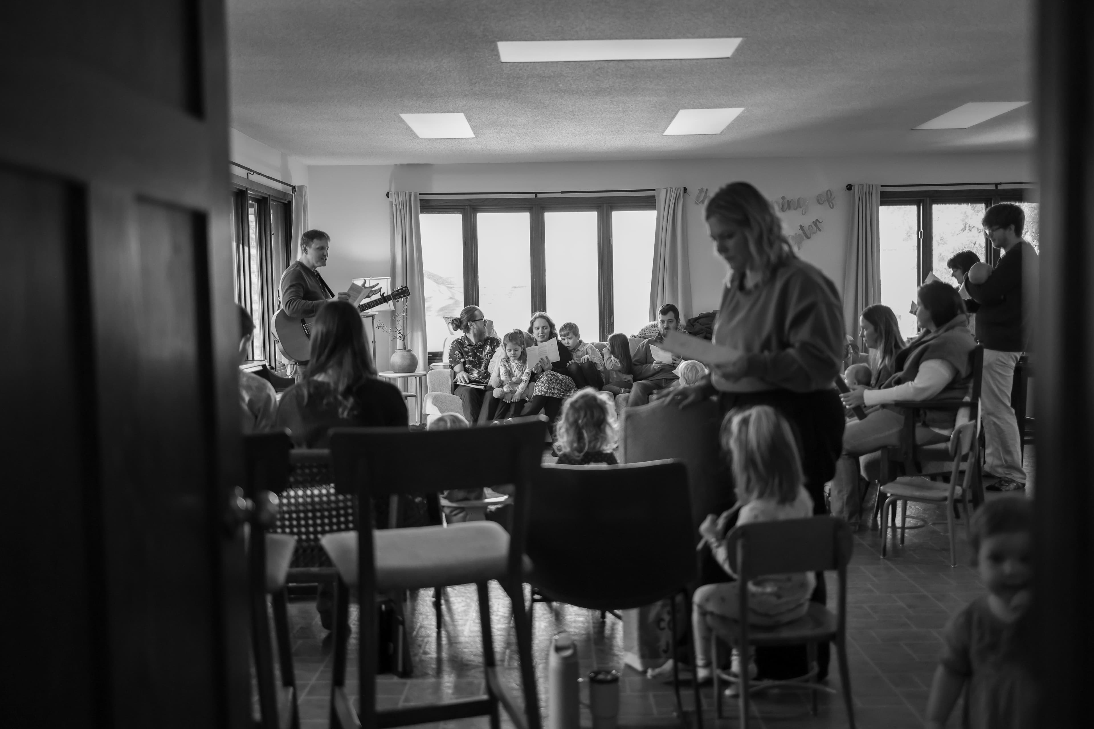 Families gathered in a living room for worship and teaching