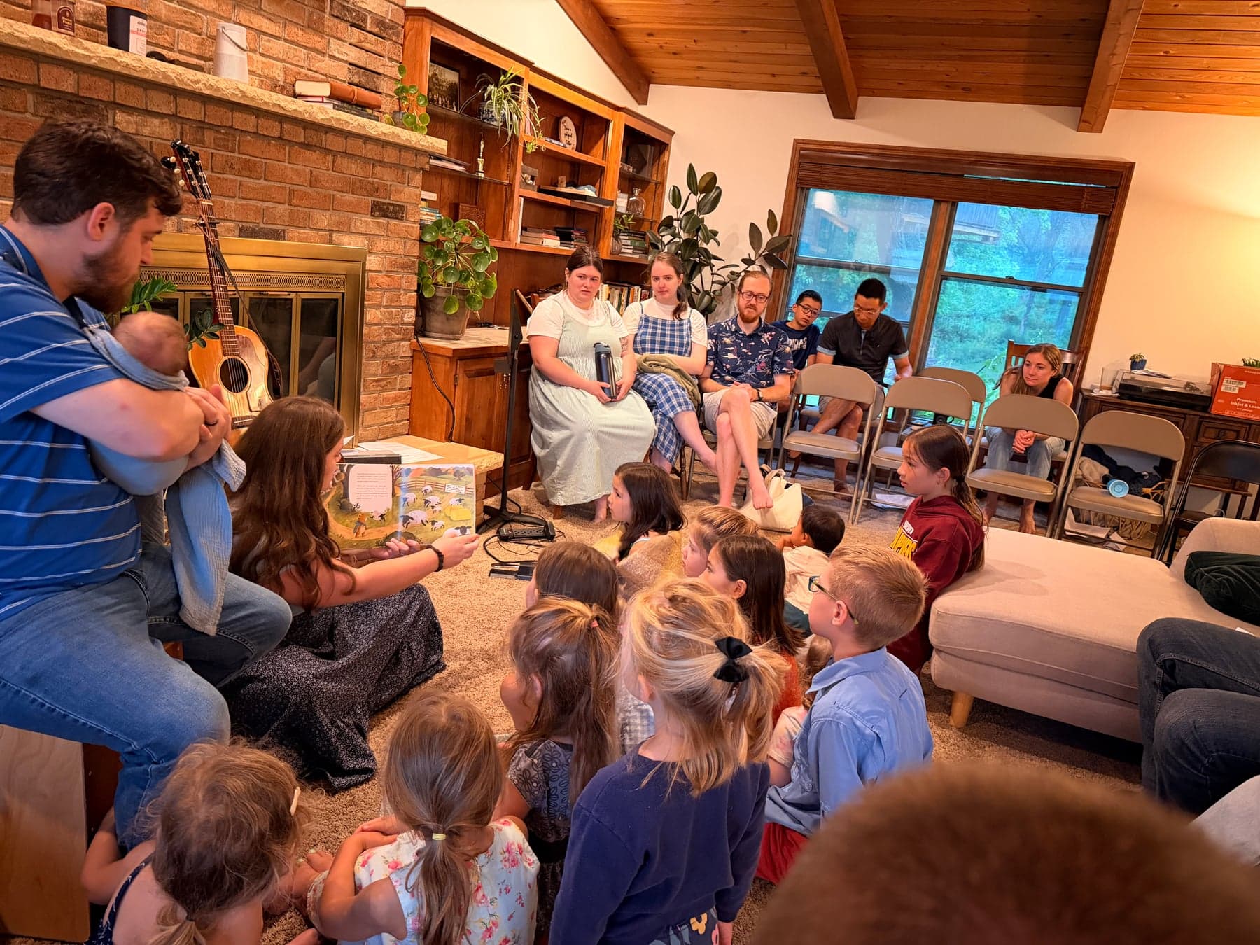 Adults and children gathered in a living room for teaching